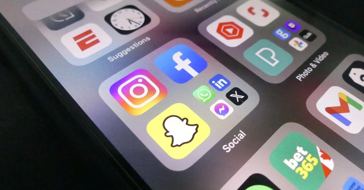 Vue rapprochée de l'écran d'un smartphone présentant des icônes d'applications de médias sociaux populaires.